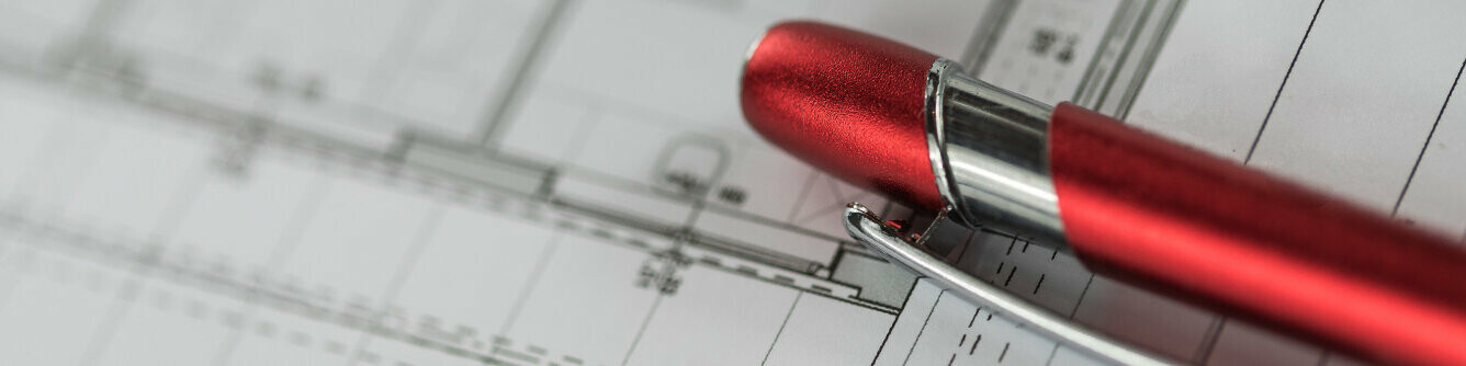 Czerwony długopis PREFA na planie projektowym. 