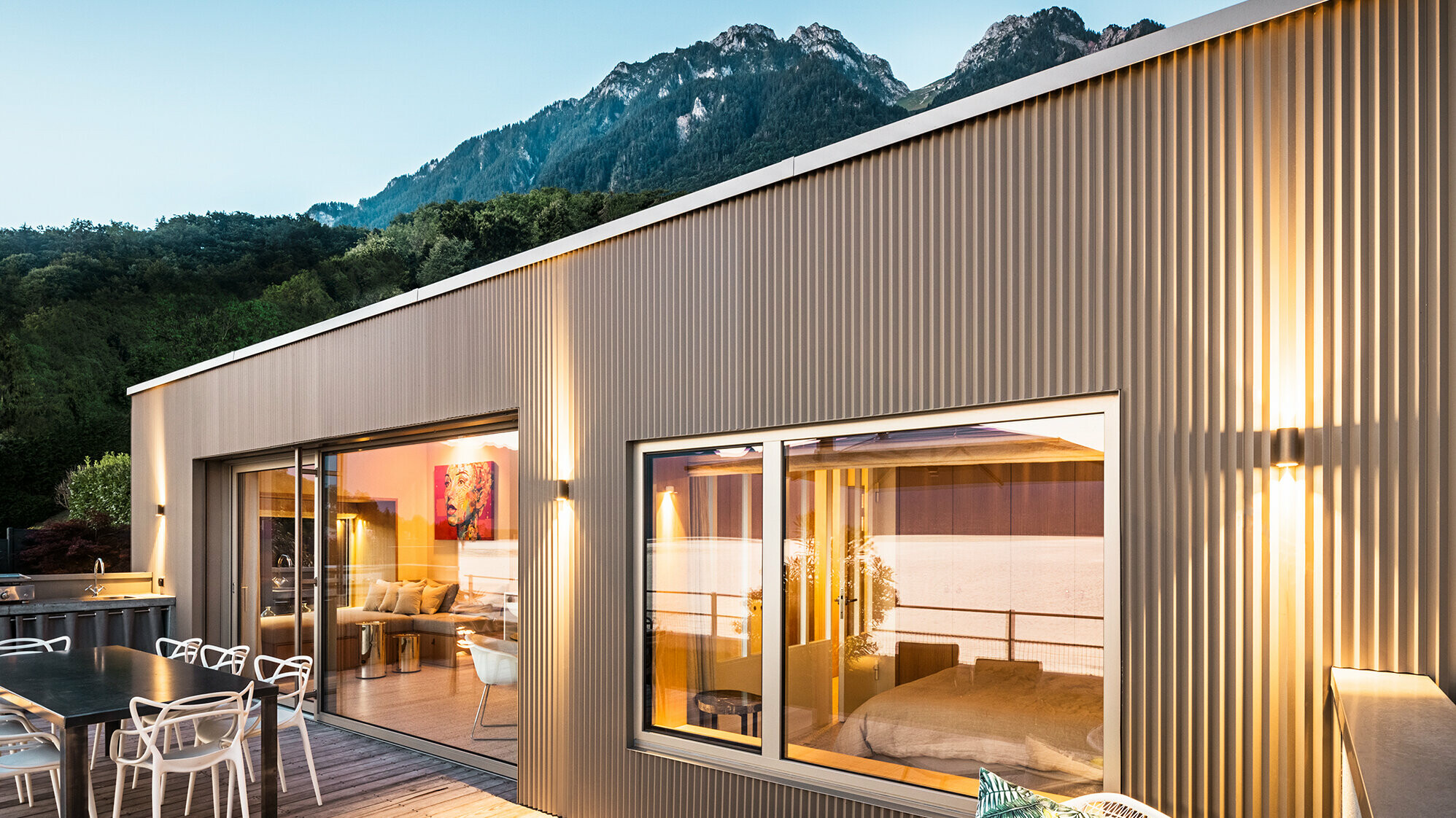 Widok na taras i część wnętrza budynku wieczorem.