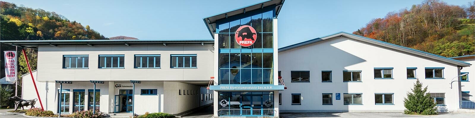 Budynek firmy PREFA z białą fasadą i niebieskimi oknami