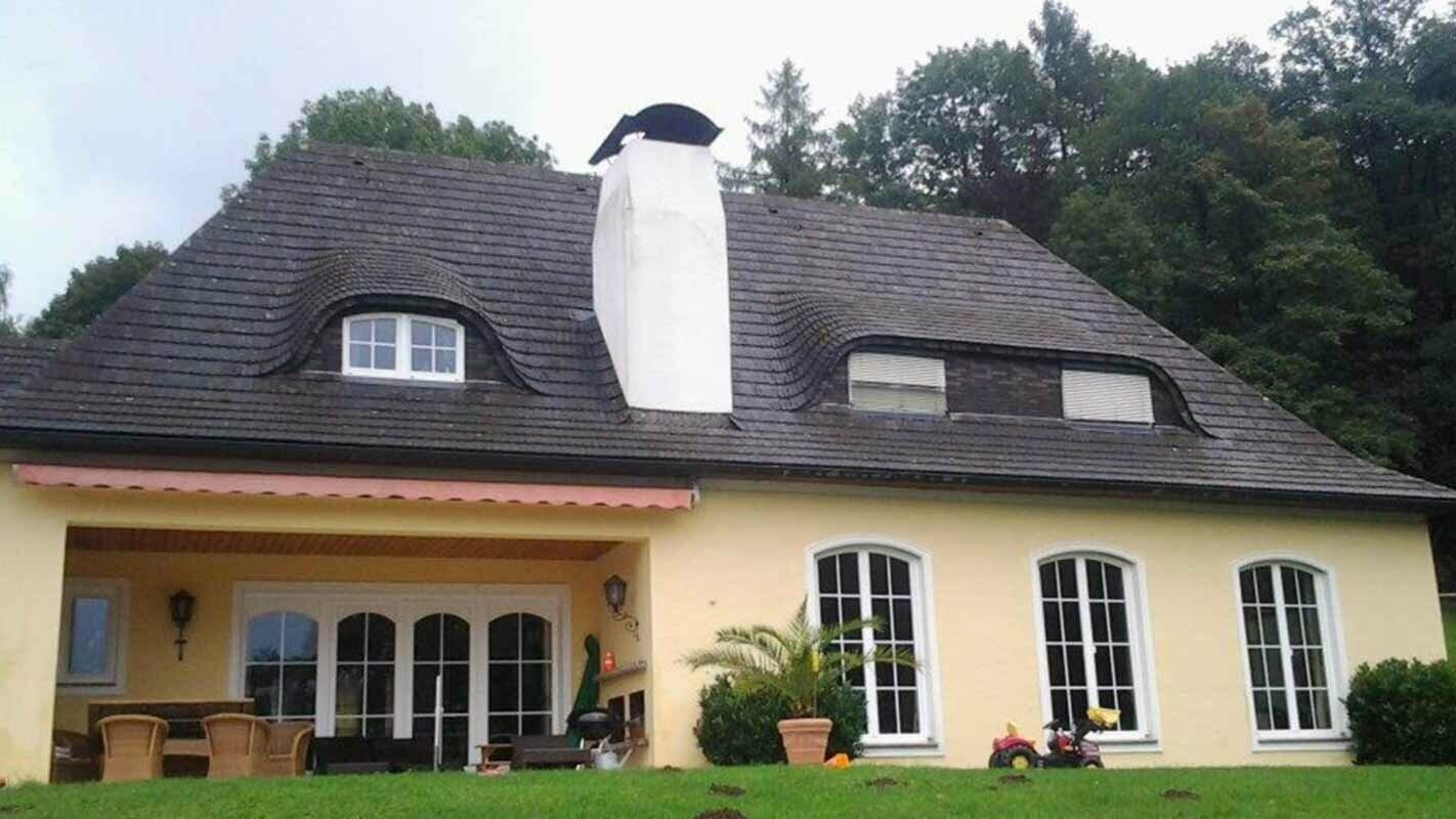 Dach budynku i wole oko po modernizacji dachówką PREFA z dużym kominem