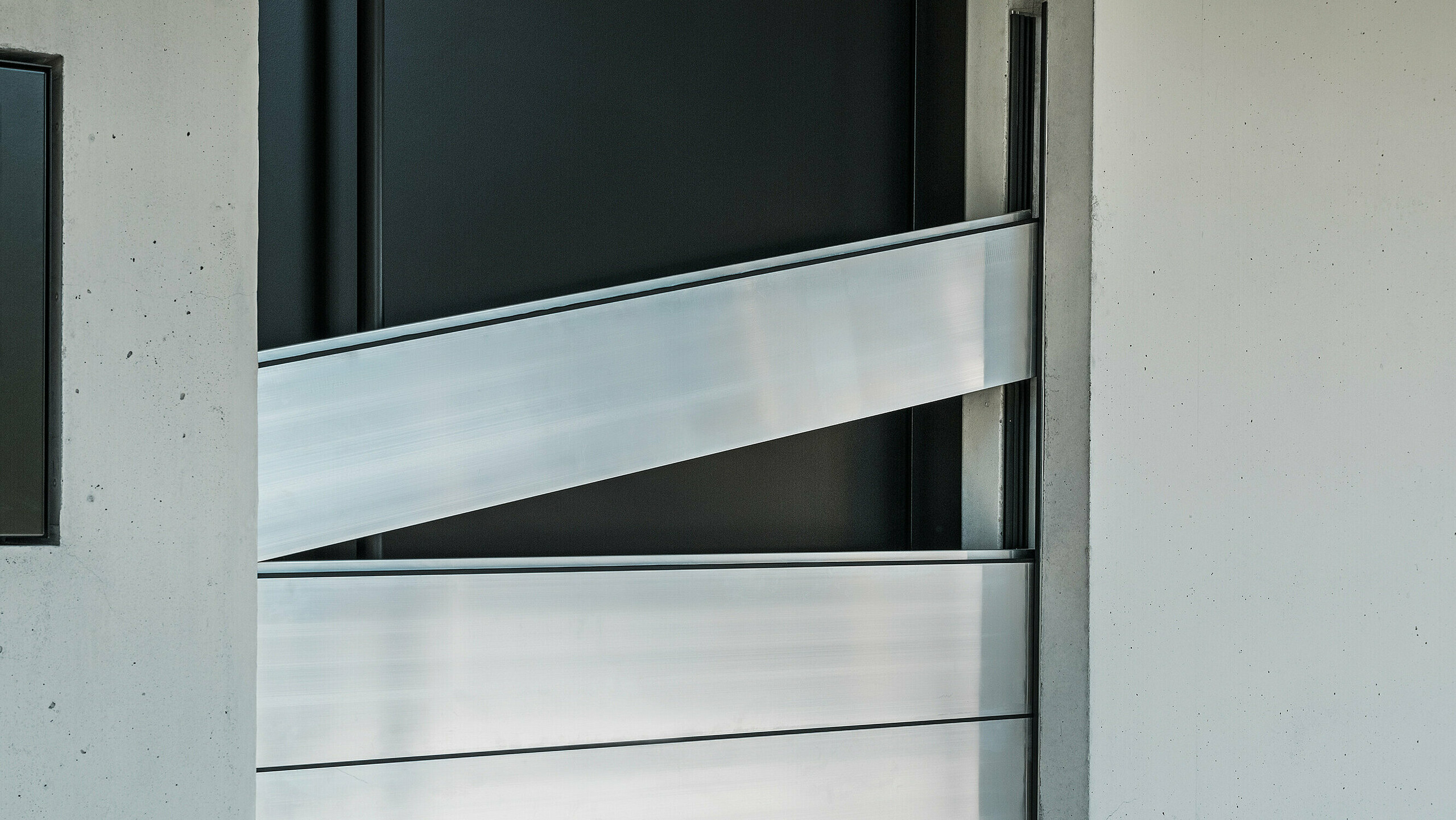 Detailansicht der Verbindungselemente des PREFA Hochwasserschutzsystems. Die innovative Technik sorgt für eine sichere Abdichtung der Haustür und schützt effektiv vor Hochwasser. Die Dammbalken werden schräg eingeschoben, wie am oberen Element deutlich zu erkennen ist.