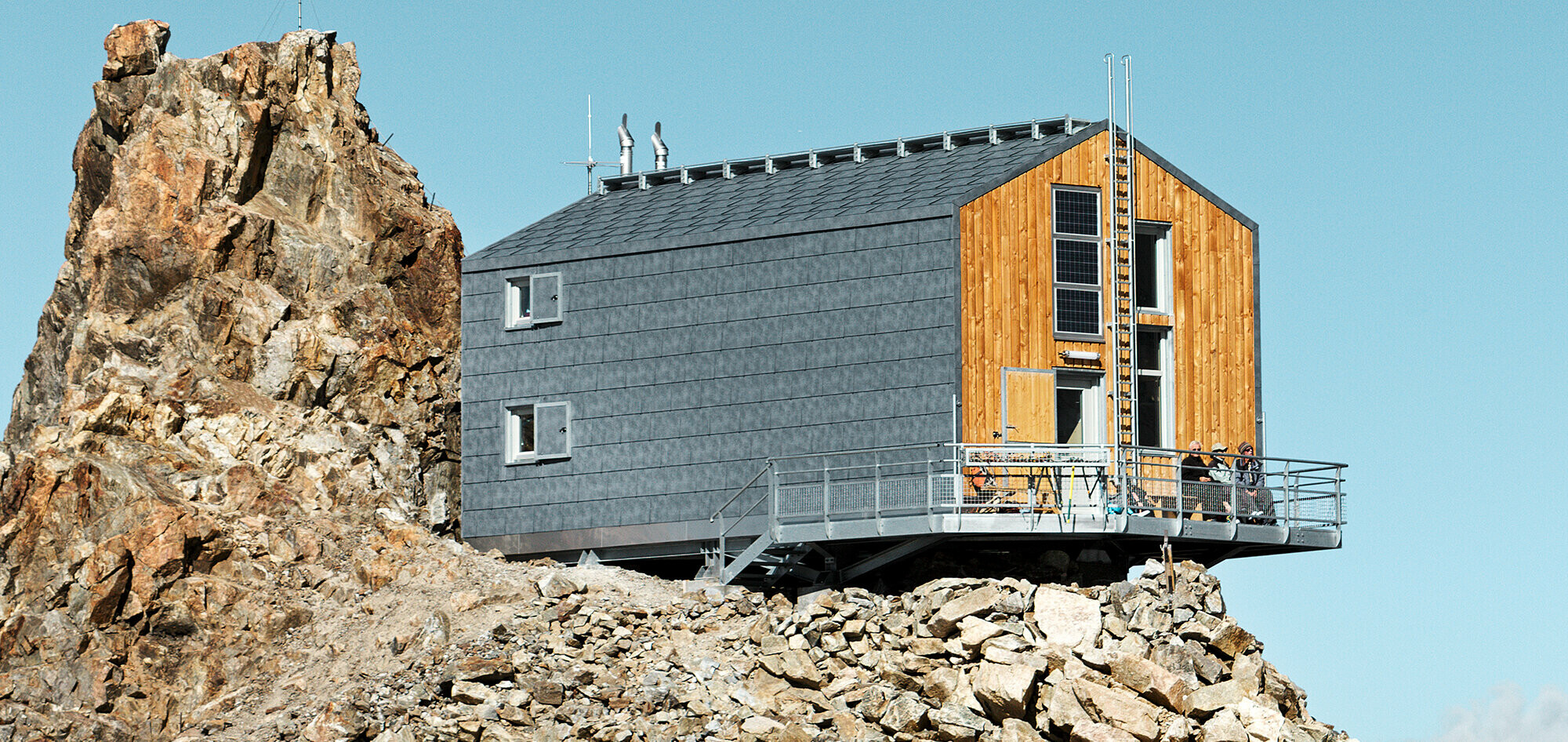 Odremontowane schronisko Refuge de L´Aigle pokryte panelami dachowymi i elewacyjnymi PREFA FX.12 w kolorze  szary kamienny P.10.