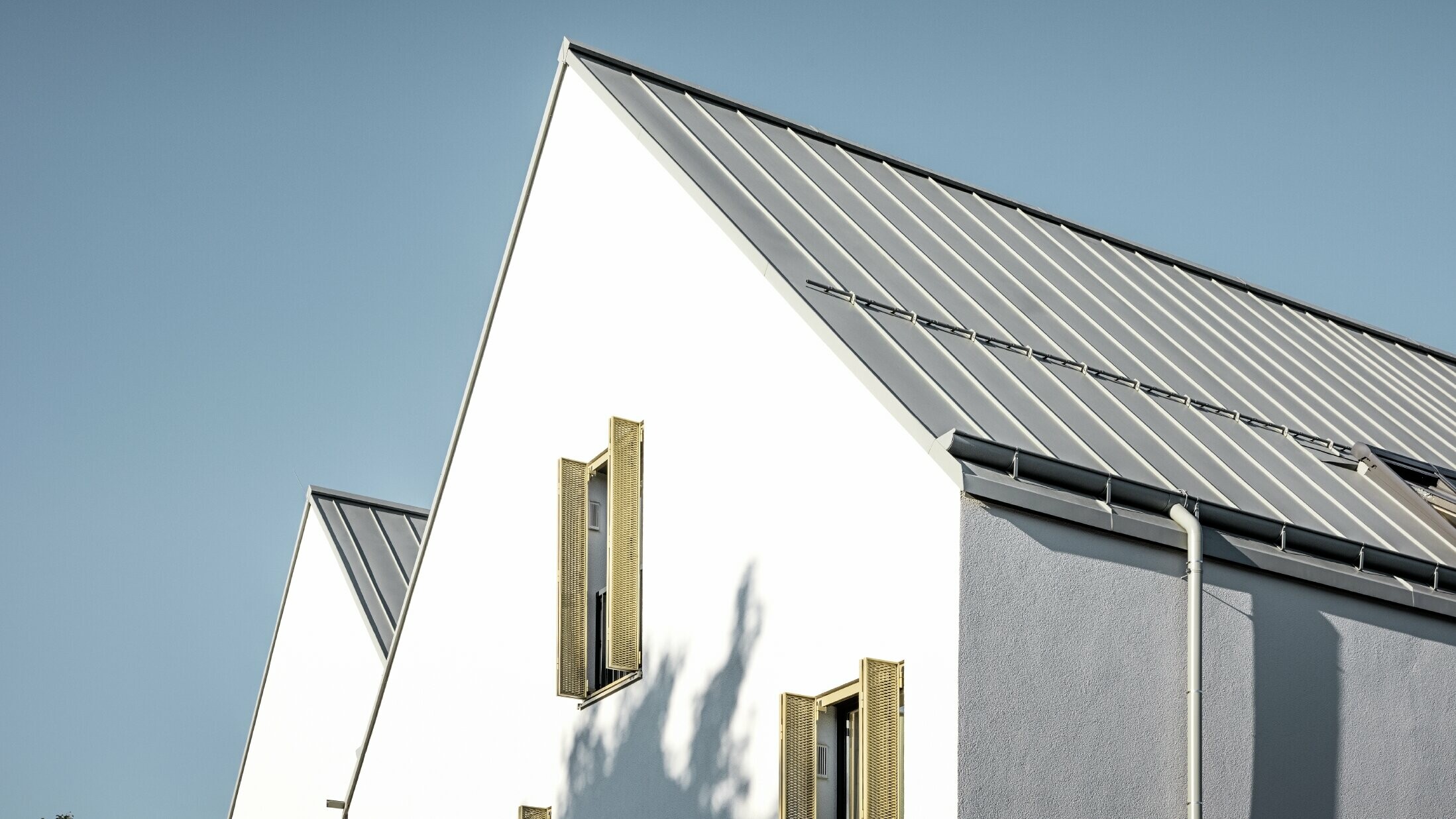 Dach dwuspadowy bez okapu, pokryty PREFALZ w kolorze P.10 szarocynkowy, z rynną leżącą PREFA