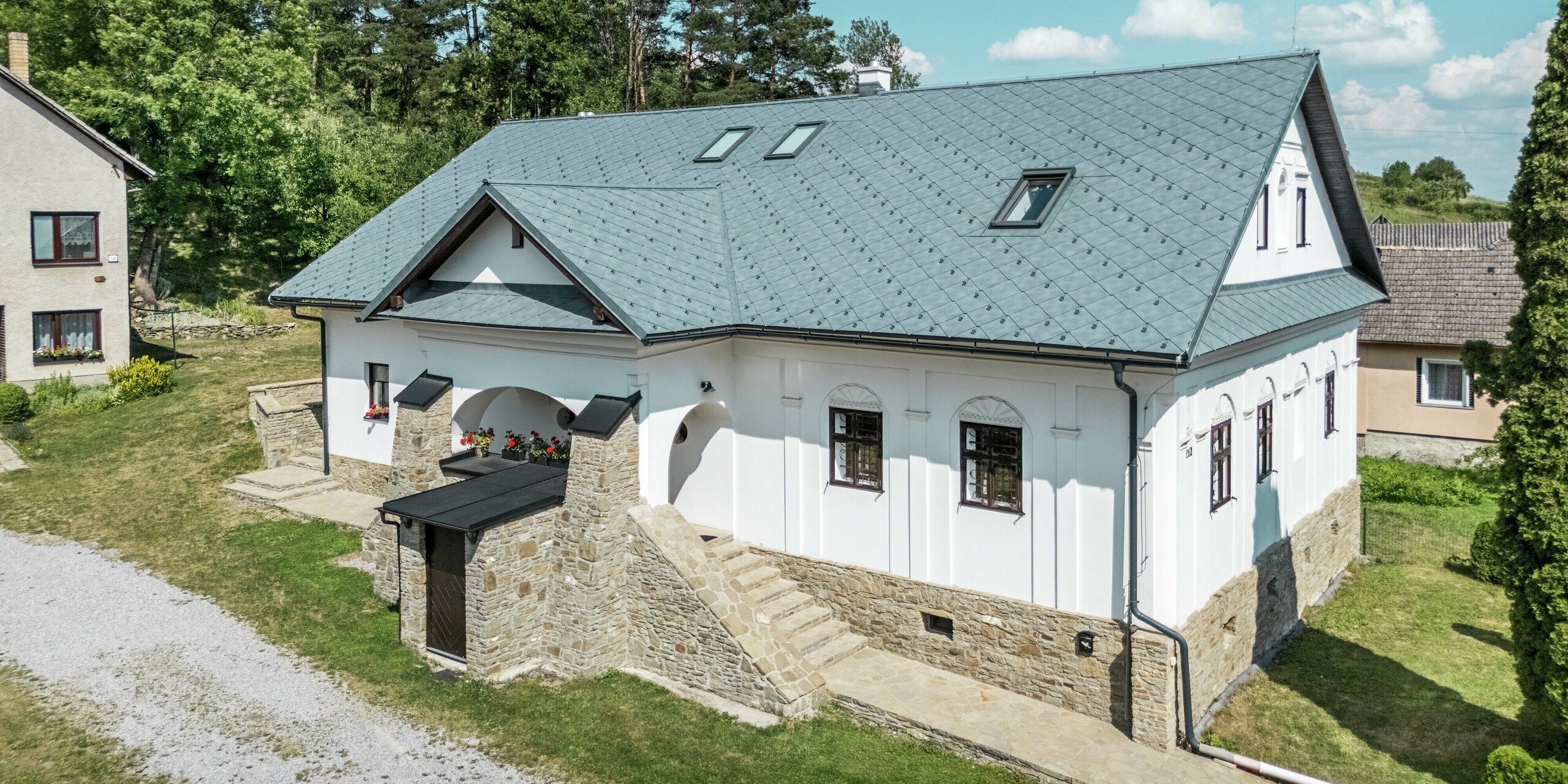 Das prächtige Handwerkerhaus in Klin, Slowakei, zeigt sich mit einem modernen Aluminiumdach aus PREFA Dachrauten 44 × 44 in P.10 Steingrau. Die elegante, symmetrische Struktur der Dachrauten harmoniert perfekt mit der klassischen Architektur des Hauses. Das hochwertige Blechdach, leicht und langlebig, ergänzt die historische Fassade und sorgt für eine hohe Widerstandsfähigkeit gegen Witterungseinflüsse. Die Dachfenster bieten zusätzlich Licht und Belüftung und setzen einen modernen Akzent im traditionellen Design. Diese Dachlösung bietet nicht nur ästhetische Vorteile, sondern auch eine nachhaltige und funktionale Lösung für die Sanierung.