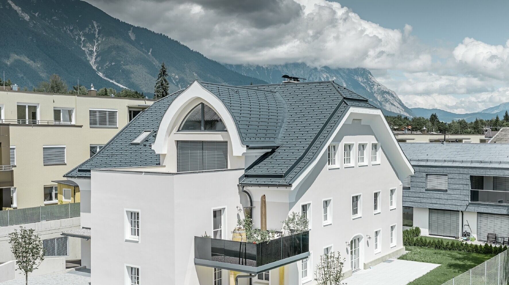 Nowo wyremontowany dach naczółkowy z zaokrągloną lukarną, kryty dachówką łupkową PREFA w kolorze P.10 antracyt