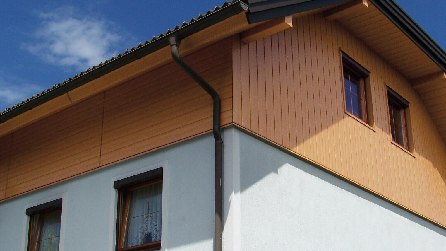 Dom jednorodzinny z poszyciem szczytu w kolorze jasnego drewna